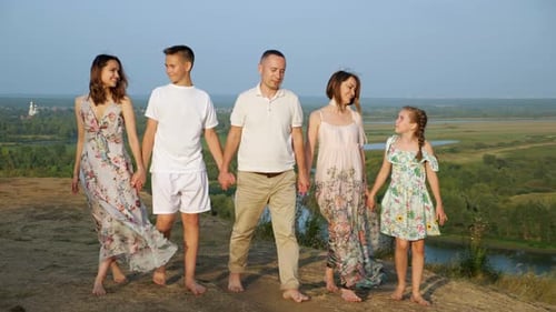 Happy Family Strolls Hand-in-Hand Through Beautiful Countryside