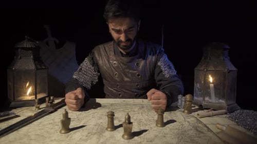 Man Dressed as Medieval Knight Studies War Map