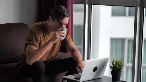Young Adult Working on Laptop at Home