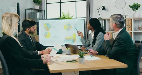 Des hommes d'affaires tiennent une séance d'information dans une salle de conférence moderne et discutent des statistiques économiques