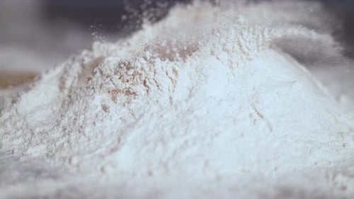 Extreme close up of egg falling into flour