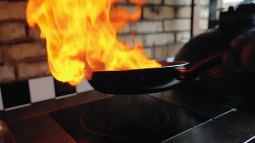 Chef Sautes Mushrooms with Flames in Restaurant