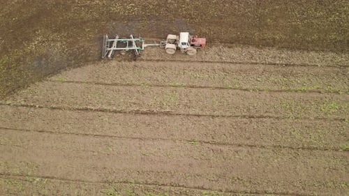 Aerial View of Tractor Plowing Agriculural Farm Field Preparing Soil for Seeding in Summer