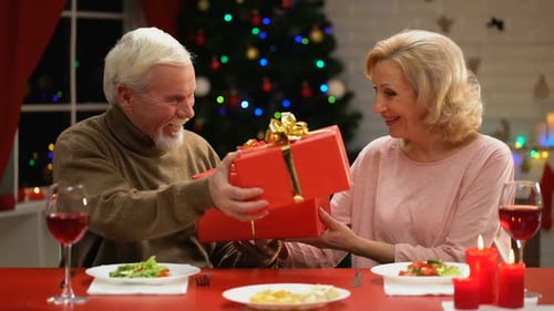 Senior Couple Exchanging Christmas Gifts at Home