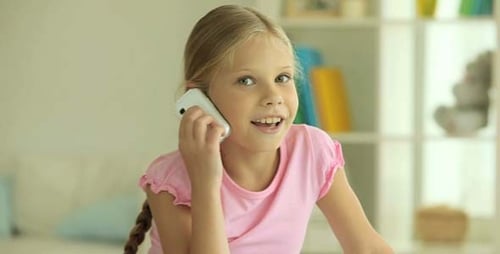 Child Speaking on Mobile Phone in Bright Room