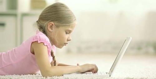 Girl Lying Down Using Laptop Computer Indoors