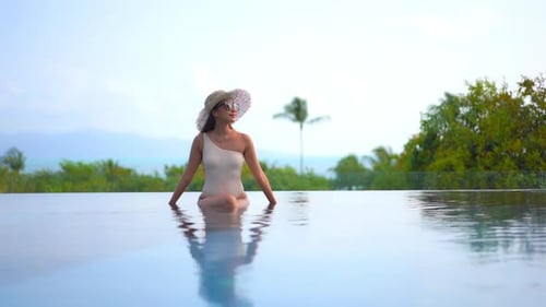 Young asian woman enjoy around outdoor swimming pool for leisure