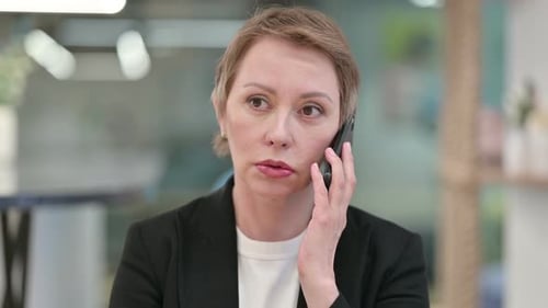 Woman Talking on Cellphone in Office Environment
