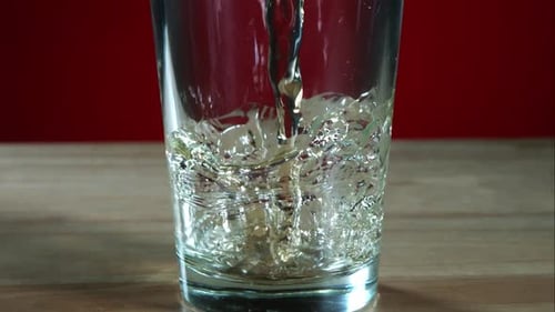 Goldfarbenes Bier, das in Ultrazeitlupe fließt