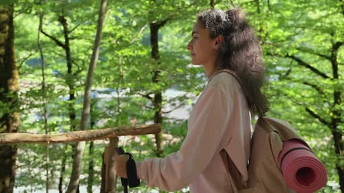 Woman with Backpack is Walking in Natural Park Exploring Forest in Summer Vacation