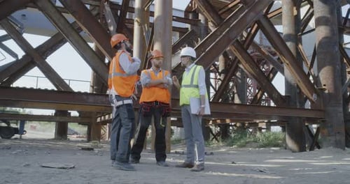 Construction Workers Discuss Plans at Site