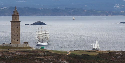 Coastal Tower with Sailboats on a Calm Ocean