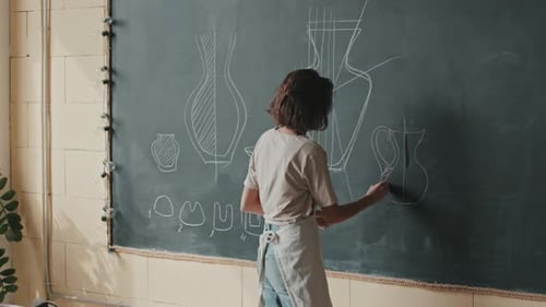 Young Adult Drawing Vase on Chalkboard
