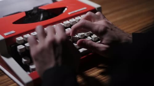 Un hombre con una camisa negra escribe texto en una máquina de escribir