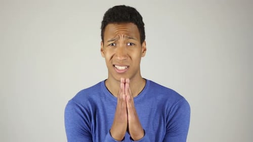 Young Man Pleading With Hands Together