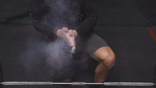 Weightlifter Prepares for Workout with Chalk