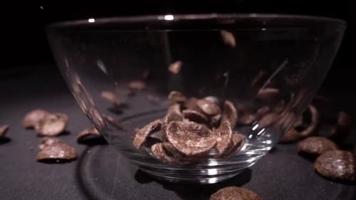 Chocolate Cereal Falling Into Glass Bowl Close Up
