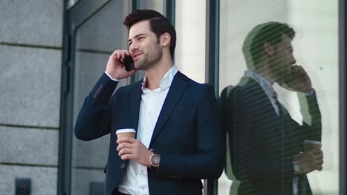 Smiling Businessman Talking on Smartphone Outside Office Building