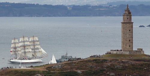 Tall Ship Sails By Coastal Tower on Ocean