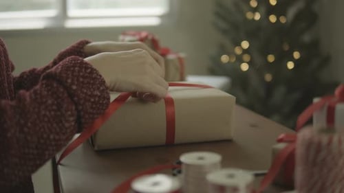 Hands Tying Ribbon on Christmas Gift