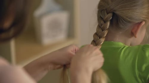Big Sister or Babysitter Braiding Little Girl's Hair, Woman Taking Care of Child