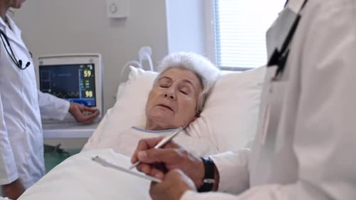 Elderly Patient Talking to Doctor in Hospital Ward