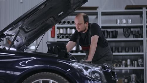 Automechaniker arbeiten mit Auto-Diagnosewerkzeug in einer Werkstatt