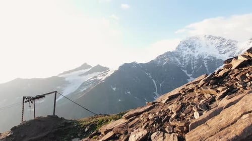 Cinematic Video of a Mountain Range and an Old Cable Car on the Background of a High Snowy Mountain