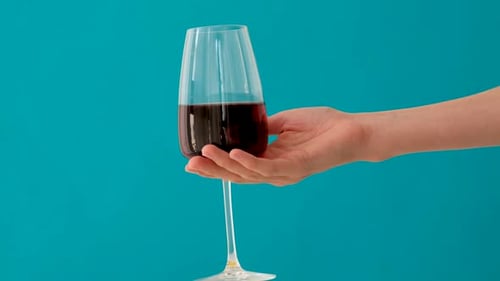 Hand Holding Wine Glass with Red Wine