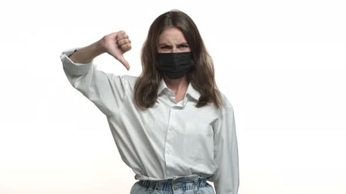 Woman Wearing Mask Giving Thumbs Down Gesture
