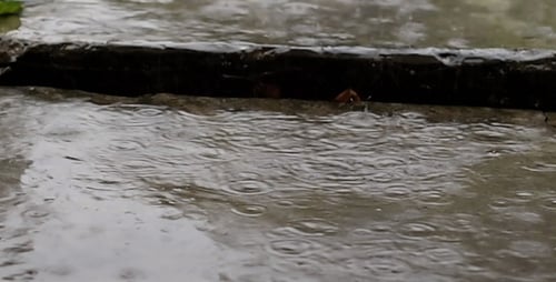 Regentropfen treffen auf die Betonplatten