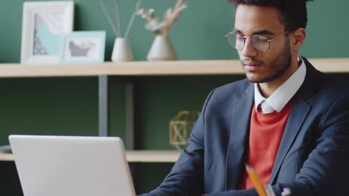 Young Mixed Race Businessman Using Laptop in Office