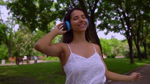 Woman Enjoys Music in Sunny Park Setting