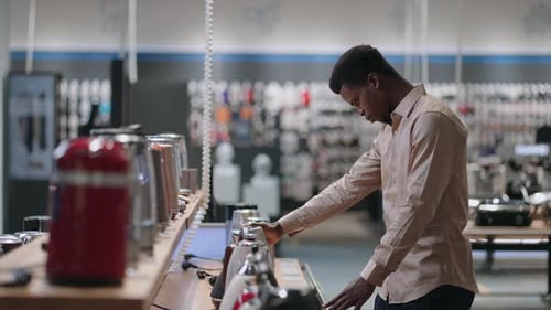 Young Black Man is Choosing Electric Kettle Shopping in Home Appliance Store in Mall