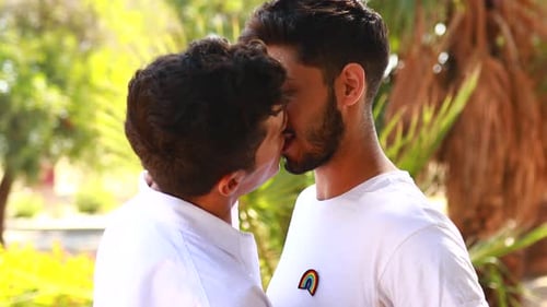 Loving Gay Couple Kissing in a Sunny Garden
