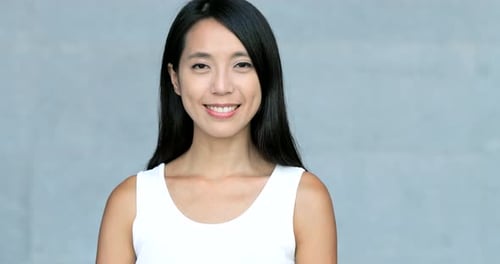 Asian young woman smile to camera over grey background