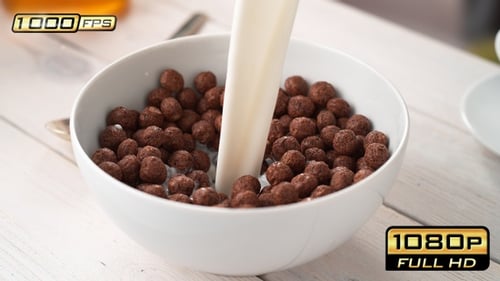 Milk poured into chocolate cereal balls in bowl