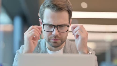 Close up of Casual Man with Laptop having Headache