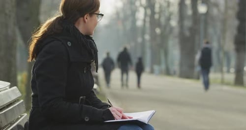 Relaxing in a park and writing in a notebook
