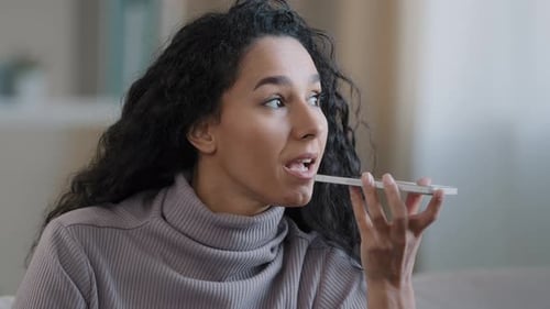 Woman Talking Into Cell Phone at Home