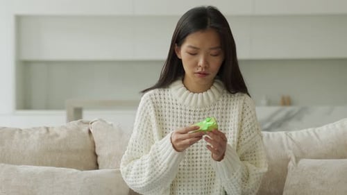 Woman Opens Birthday Gift at Home, Smiling