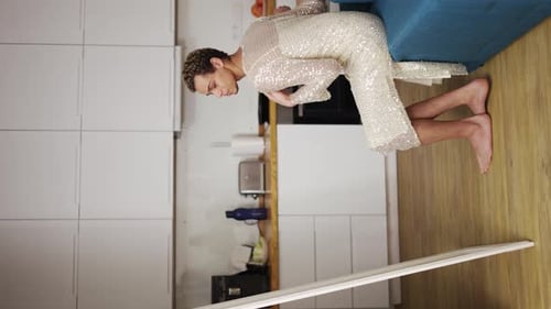 Um homem em um vestido se admira em pé na frente do espelho