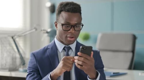 Portrait of African Man Celebrating on Smartphone