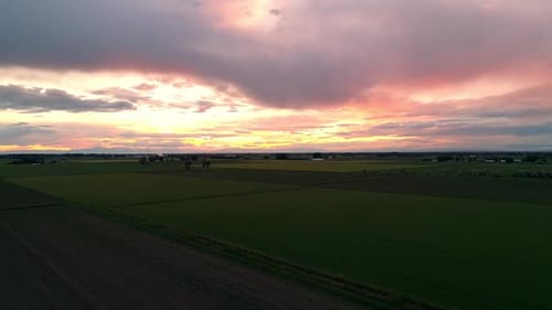 Colorful sunset over farm fields while flying towards sunset