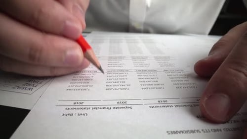 Accountant Analyzing Business Marketing Data on Paper Dashboard at Office Table