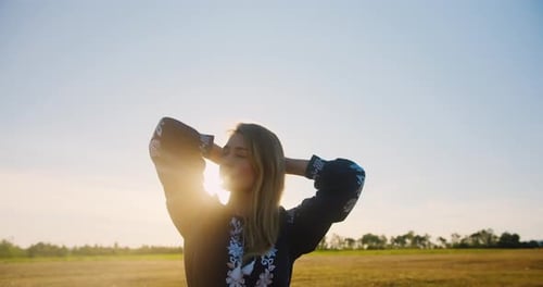 Woman posing and acting on a wheat field at sunset or sunrise