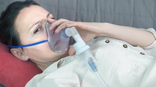 Femme avec masque d'inhalation