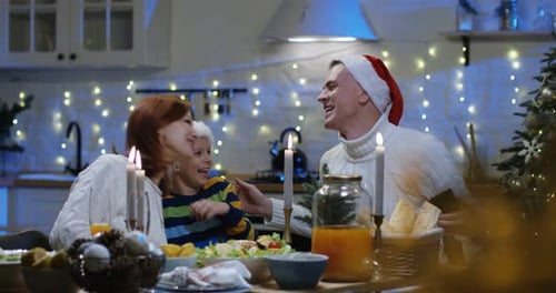 Family Watching Photos at Christmas Table