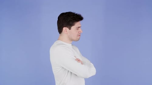 Annoyed Man Thinking with Arms Crossed on Blue