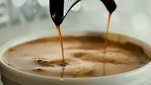 Espresso Pouring from Portafilter into White Cup